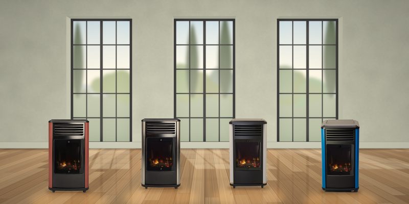 Les quatre poêles à gaz Manhattan alignés sur un parquet devant de grandes fenêtres à cadre noir : terracotta, noir, blanc et bleu